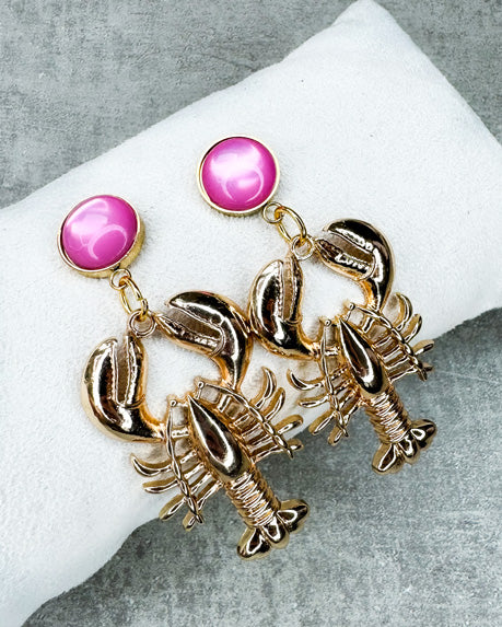 Dieser Ohrring ist gefertigt aus einem Cabochon-Ohrsstecker aus rostfreiem Stahl mit einem glänzenden, rosanen Cabochon-Stein und einem goldfarbenen Lobster-Anhänger.